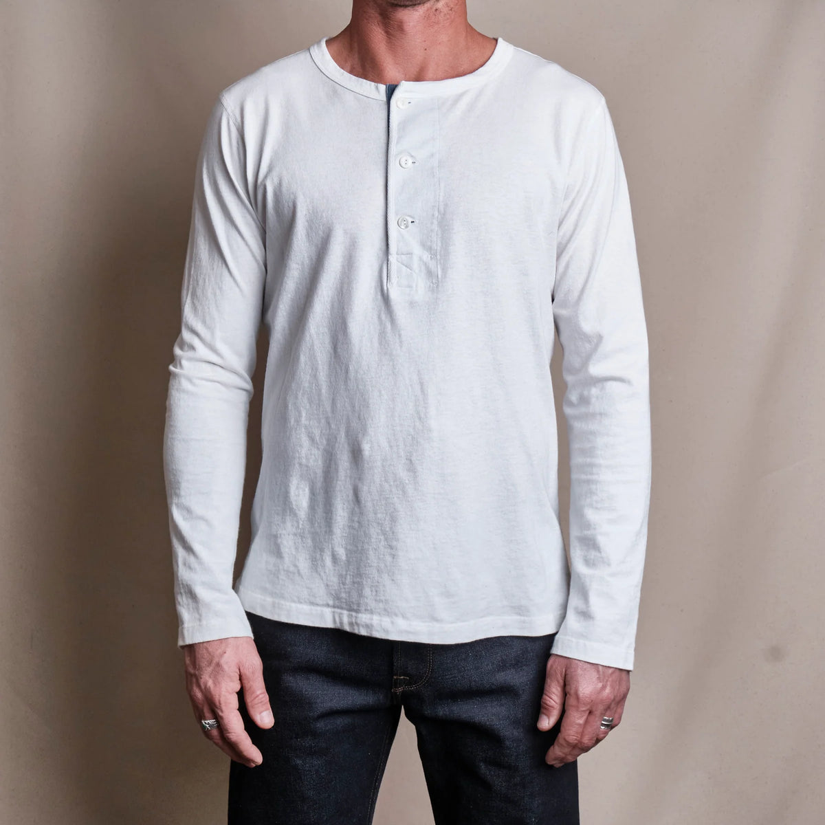 Men's white 13-ounce long-sleeve Henley shirt by Freenote Cloth, featuring a classic button-up collar and ribbed cuffs.