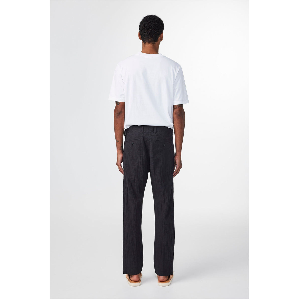 Men's black Bill Seersucker trousers by NN07, tailored fit with textured seersucker fabric, shown on a model.