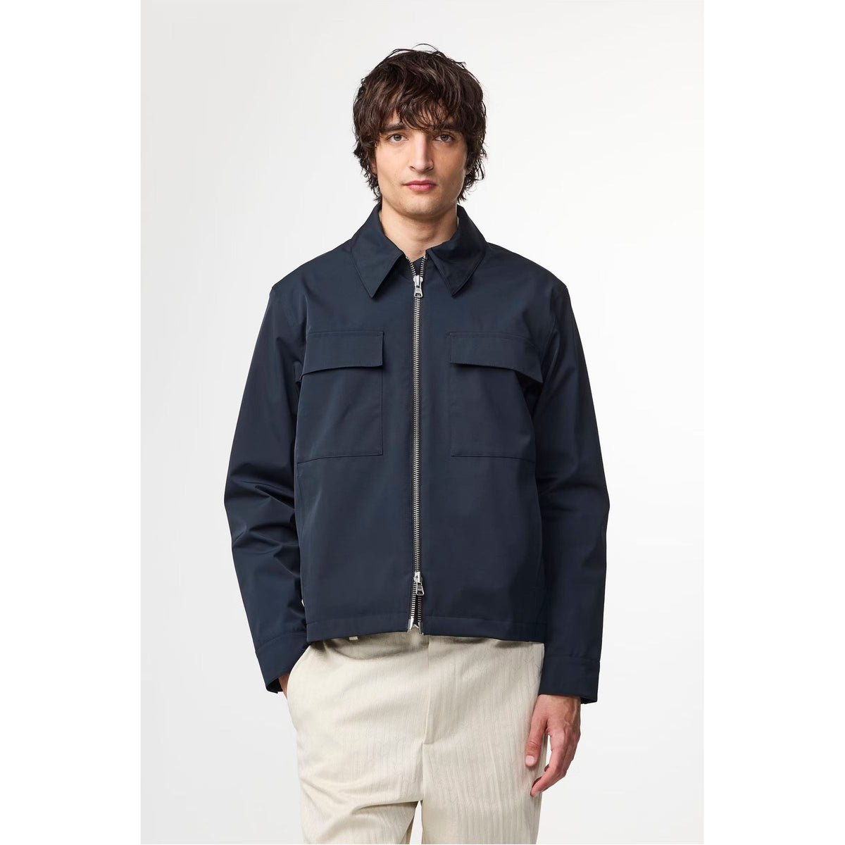Men's navy blue Alban Technical Jacket by NN07, showing the lightweight waterproof outer layer with a hood and zip closure.