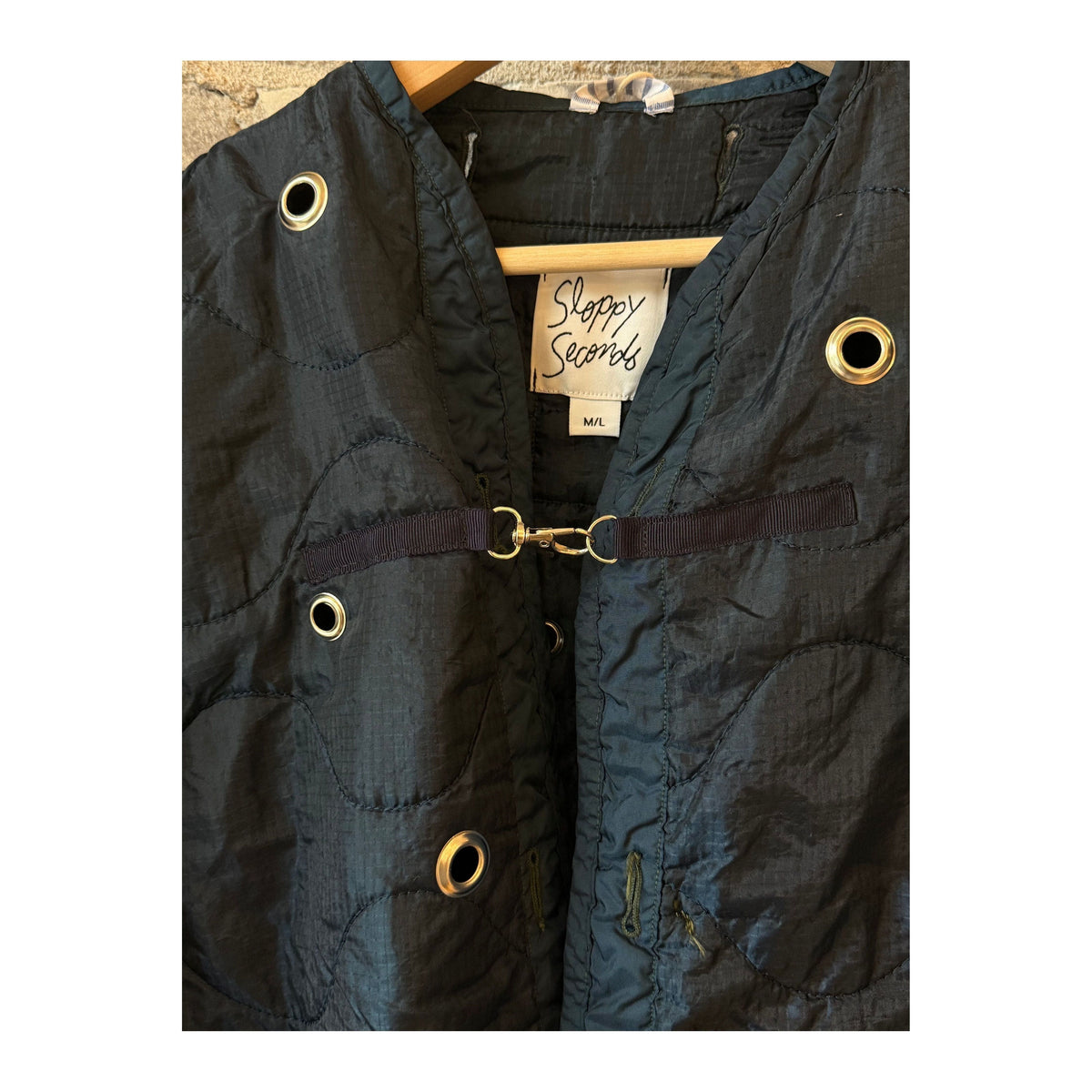 Women's navy military liner grommets by Sloppy Seconds, showing close-up of metal grommets on fabric.