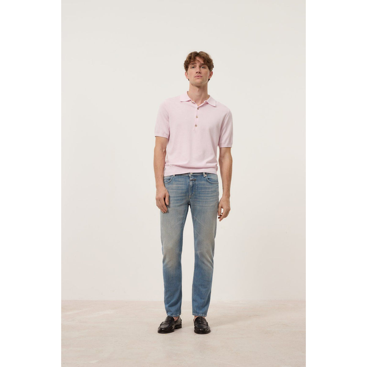 Men's Unity Slim Jean in mid blue by Closed Men's, showing a close-up of the slim fit denim fabric and stitching details.