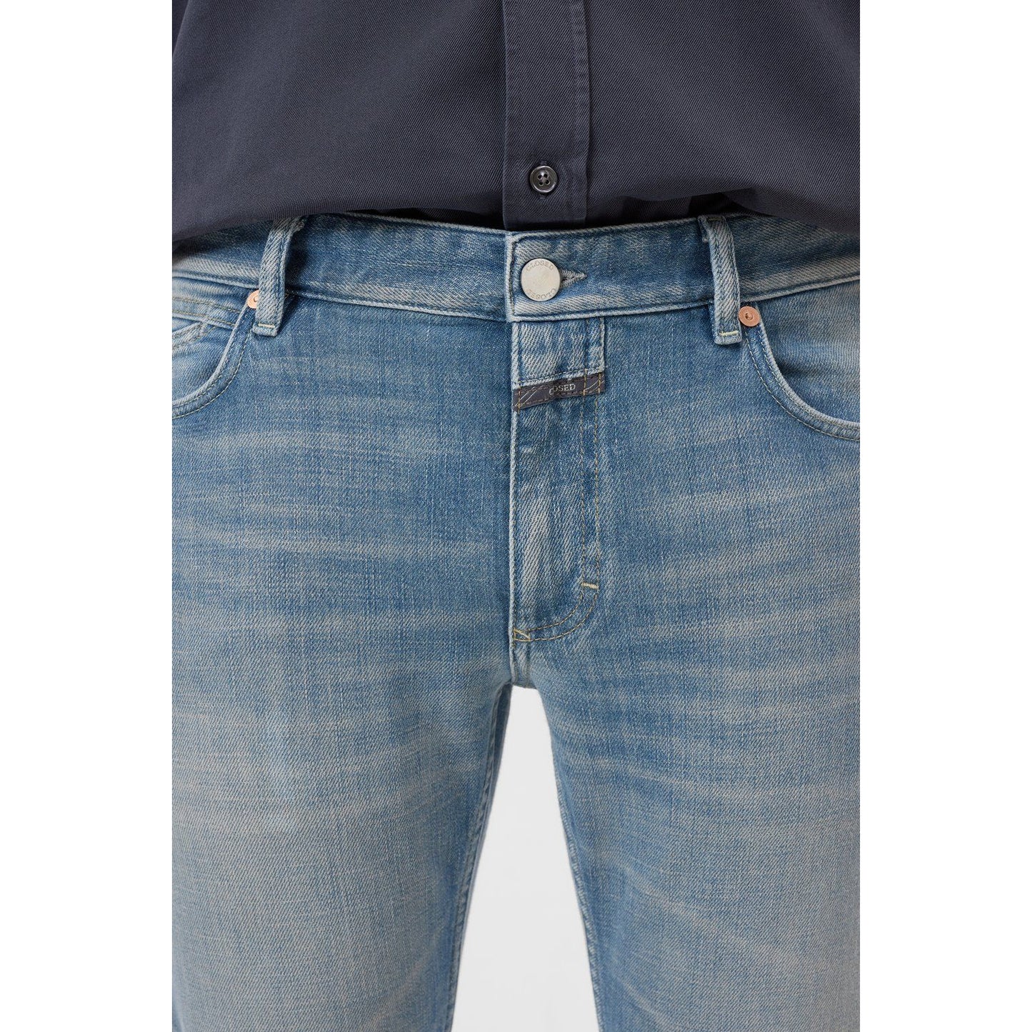 Men's Unity Slim Jean in mid blue by Closed Men's, showing a classic slim fit design and denim fabric with subtle fading.
