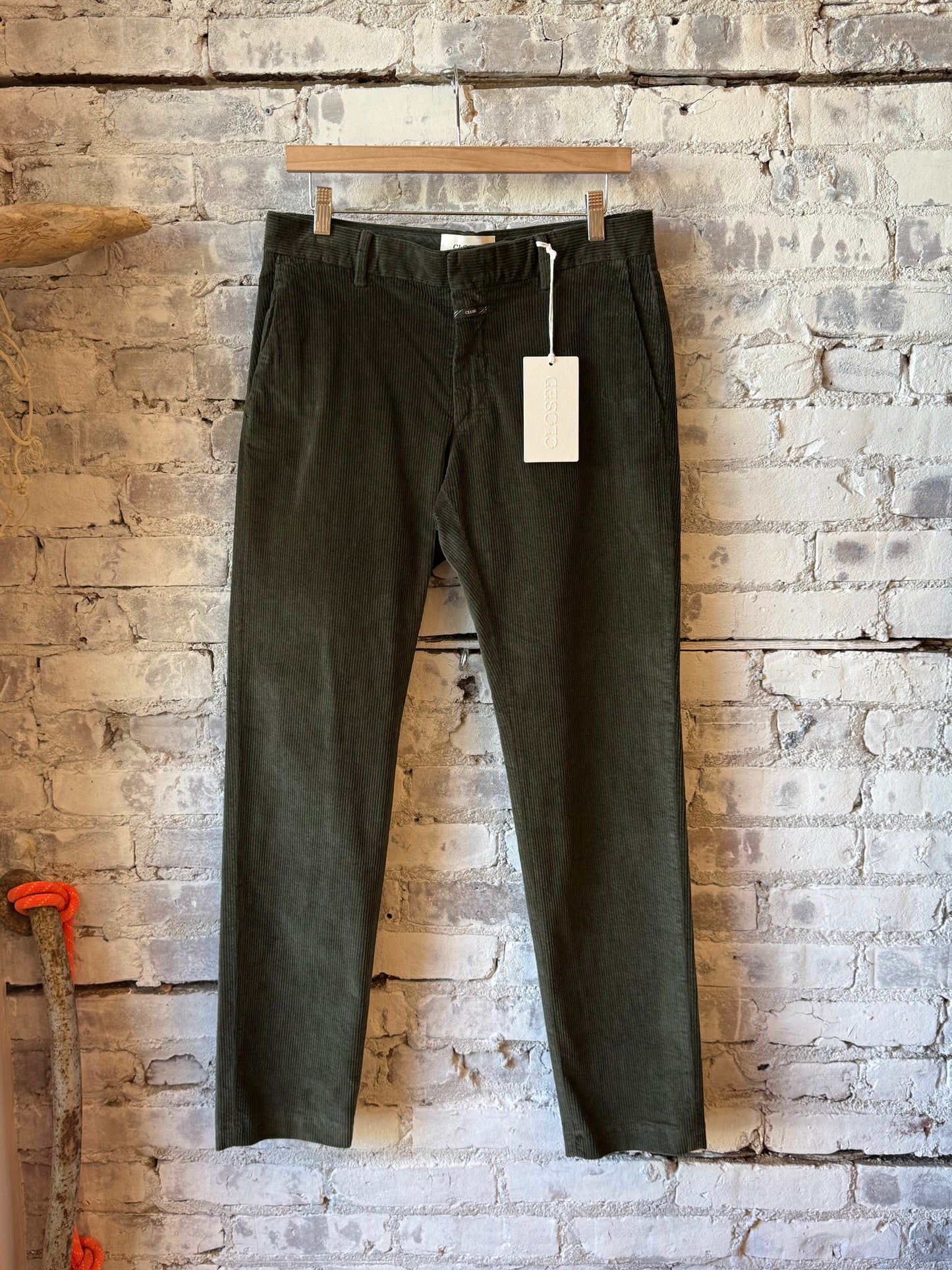 Men's Clifton True Corduroy Pants in dark olive green by Closed Men's, shown in a close-up of the textured fabric.
