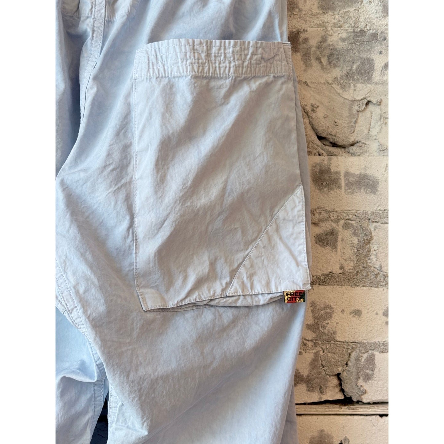Women's Freecity Homestud Outofsight Poplinair Flapsnap Kite Pant in blue, featuring a relaxed fit with flap and snap details.