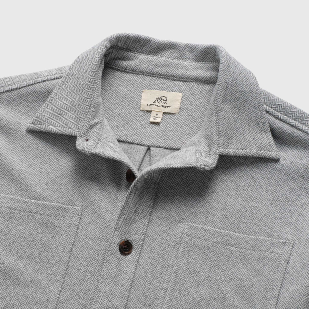 Men's Louis Soft Herringbone Overshirt in Sugar Swizzle by Surfside Supply, displayed on a hanger showing textured herringbone fabric.