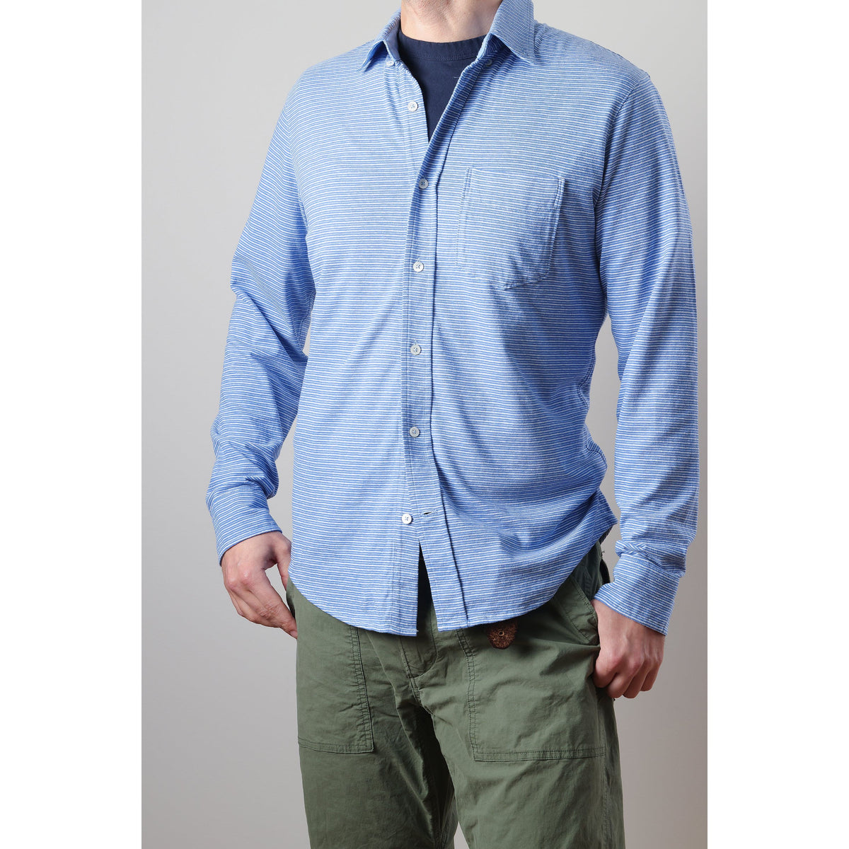 Men's hemp stripe button-down shirt by Relwen featuring marine and white vertical stripes, worn on a model.