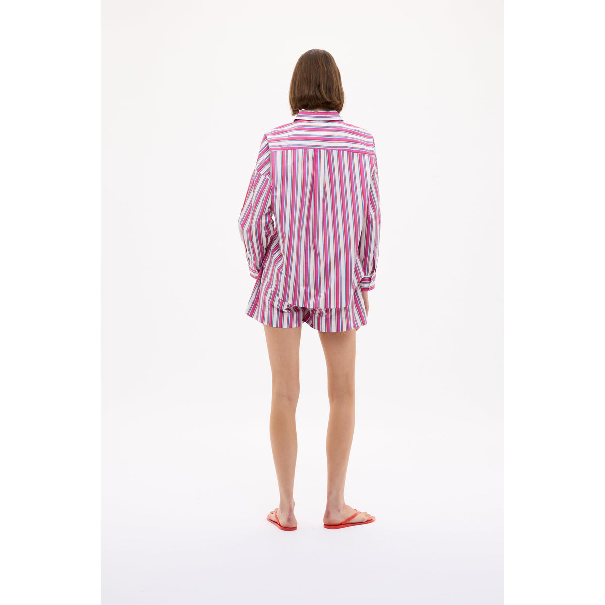 Women's Chiara Mid Length Shorts in vibrant fuchsia multi-stripe pattern by LMND, displayed on a model.