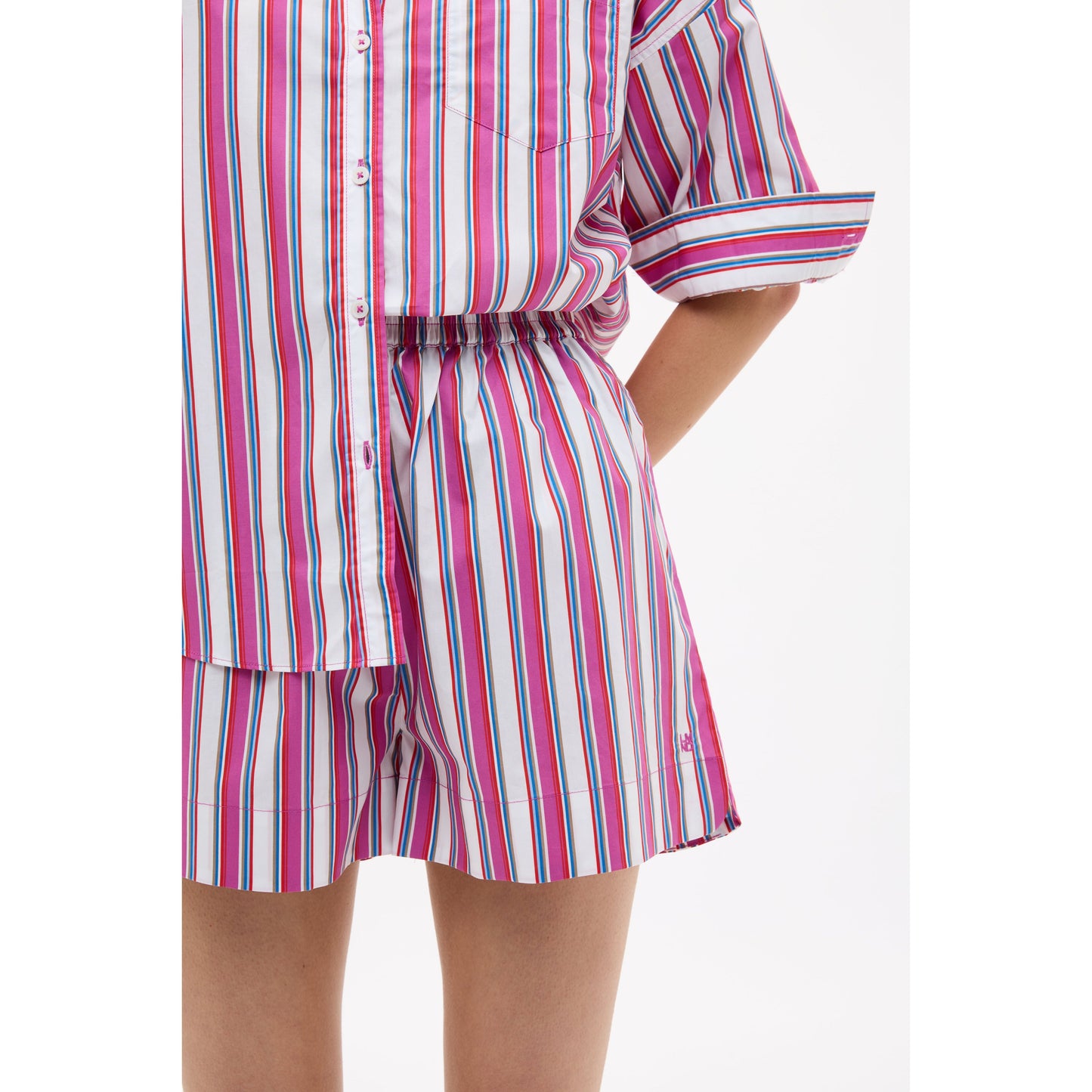 Women's Chiara mid-length shorts by LMND in vibrant fuchsia multi-stripe pattern, shown laid flat.