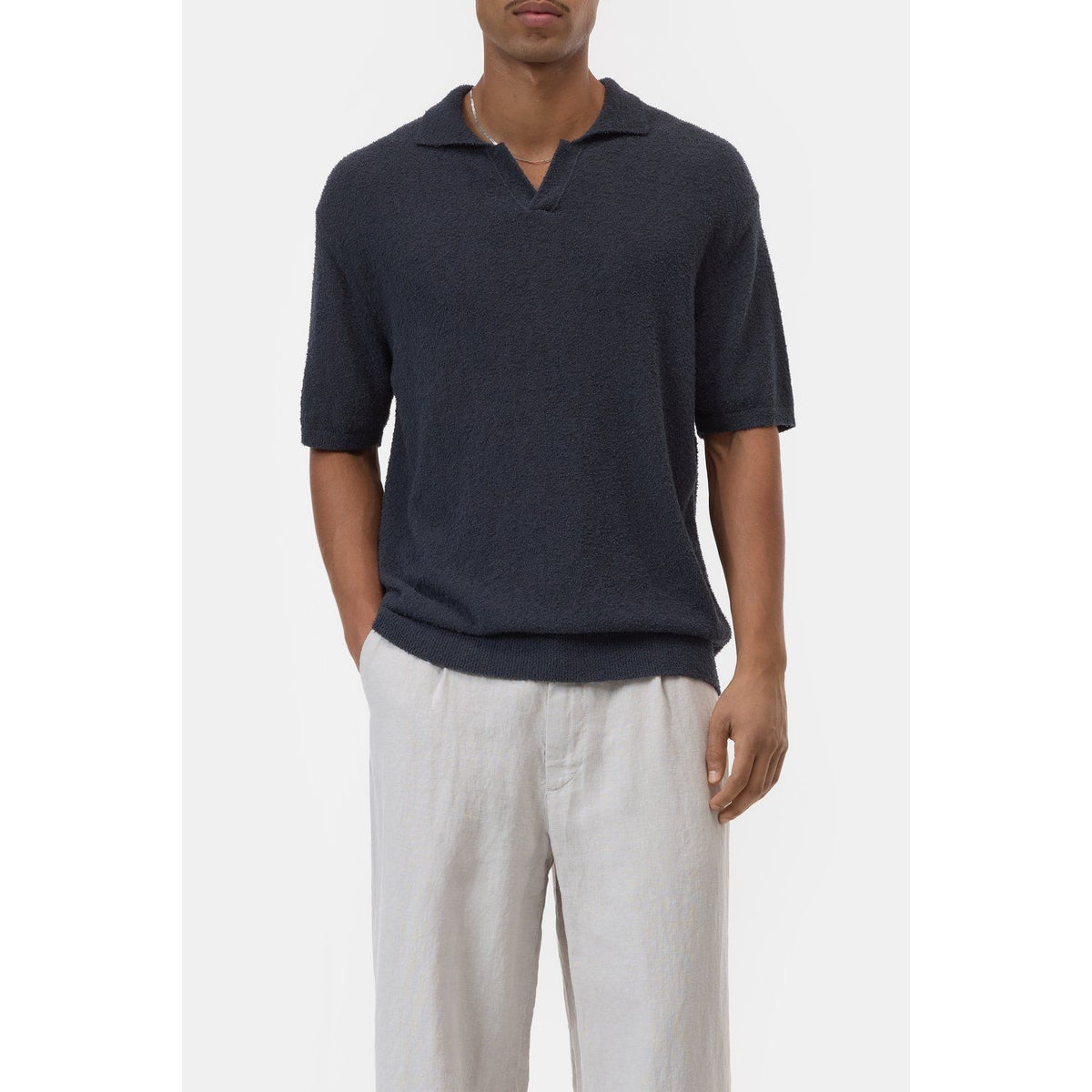 Men's cotton knit polo shirt in Magma Black by Closed Men's, close-up view showing textured fabric and classic collar.