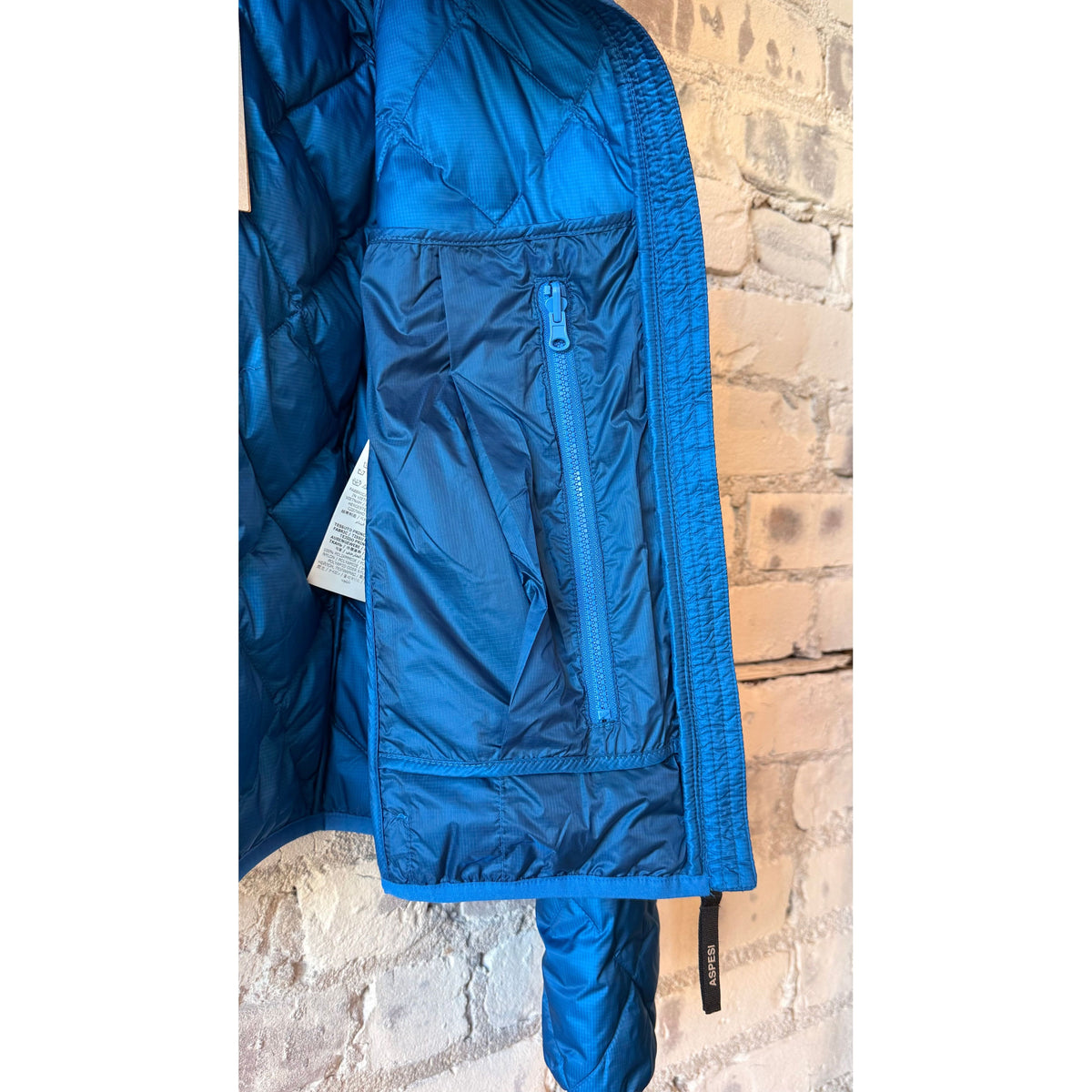 Women's Ginger Nylon Ripstop Jacket by Aspesi in azzurro, showing the lightweight, water-resistant design with a hood and zip closure.