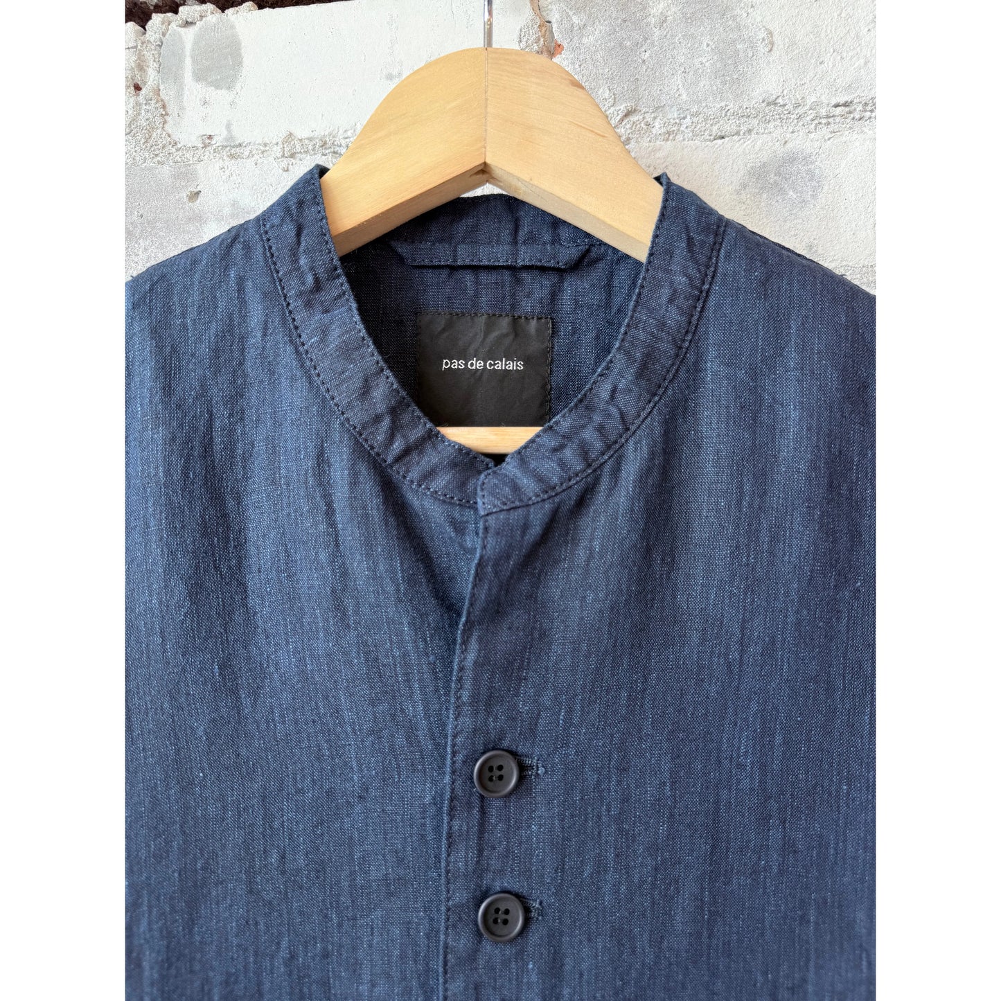 Women's dark indigo linen chambray jacket by Pas de Calais, featuring a relaxed fit and classic collar, displayed on a hanger.