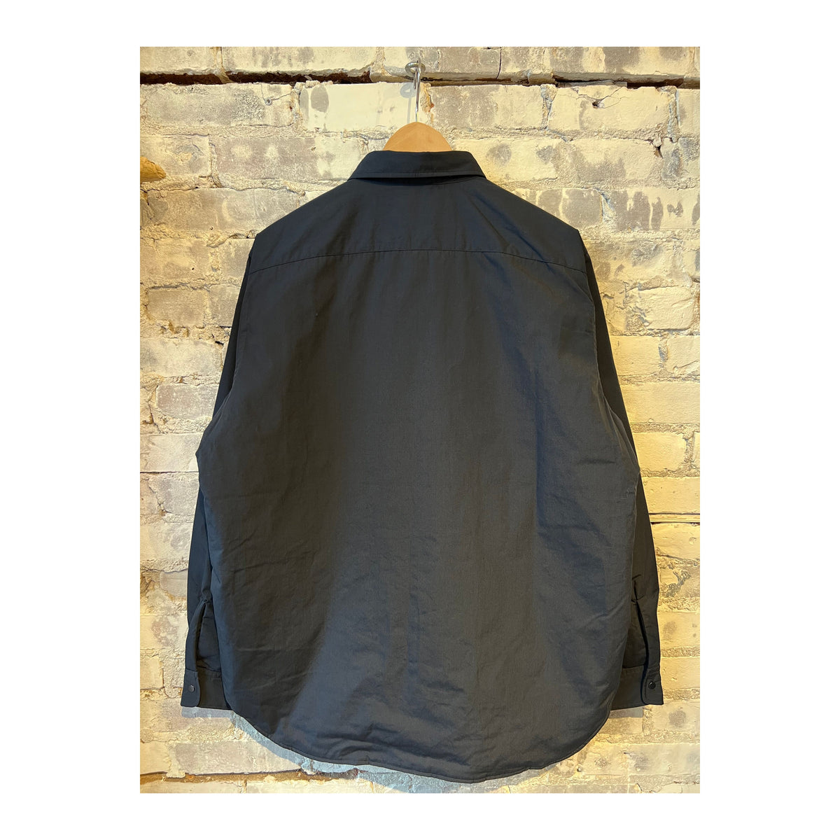 Men's nanamica insulation shirt jacket in dark navy, showing the lightweight, quilted design with a high collar and front button closure.