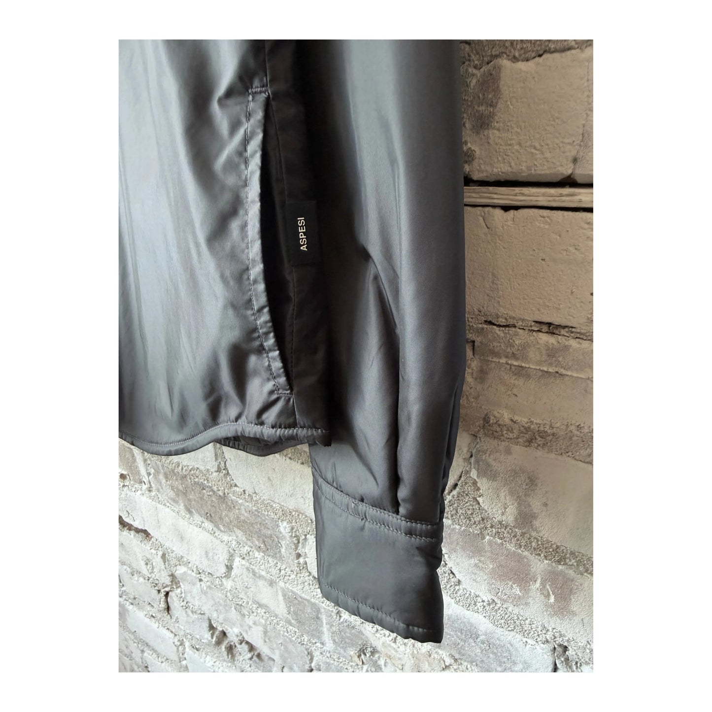 Women's grey padded nylon overshirt by Aspesi, showing a close-up of the padded fabric and stylish overshirt design.