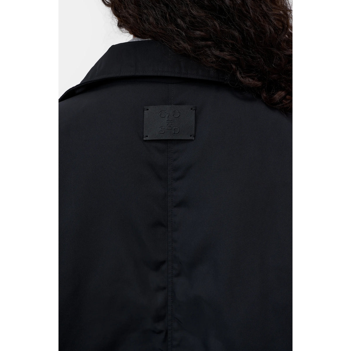 Women's black relaxed parka jacket by Closed, showing a casual, comfortable fit with a hood and zipper detail.