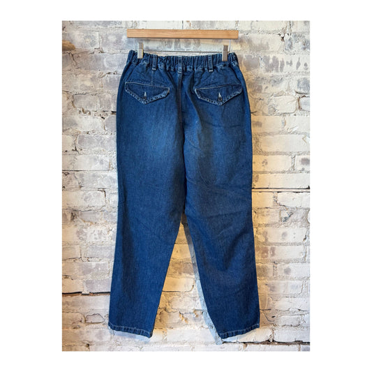 Men's indigo blue denim peg top pants by Sage De Cret, featuring a relaxed fit and classic denim texture.