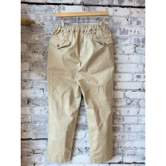 Men's beige tapered chino cloth pants by Sage De Cret, featuring a relaxed fit and classic style, shown on a model.