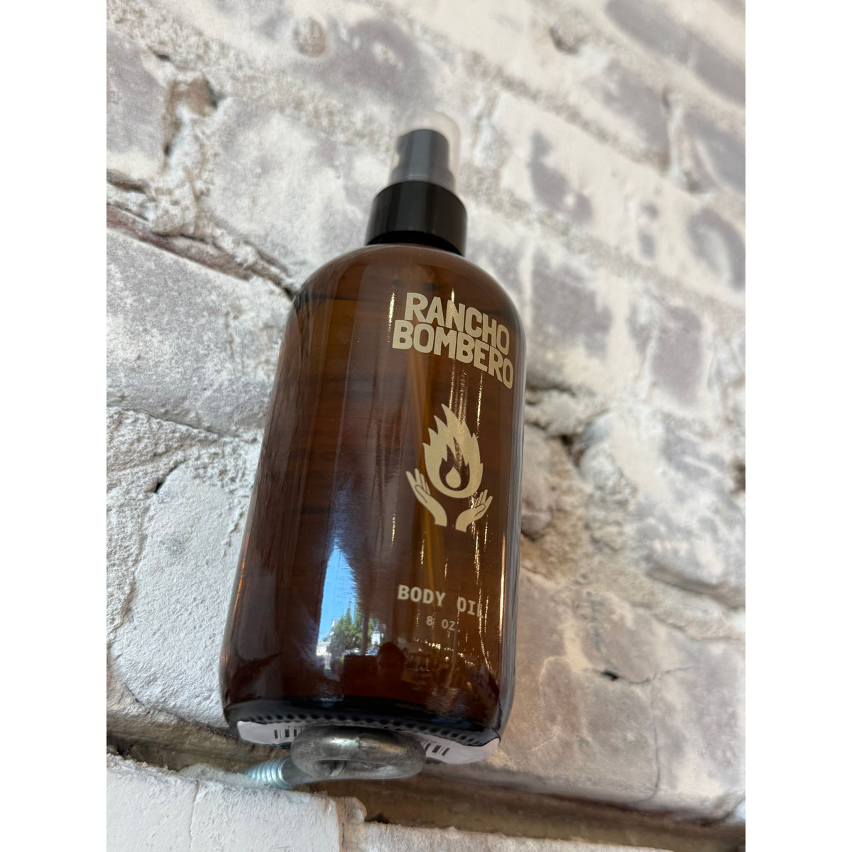 Rancho Bombero total body oil in an 8 oz. bottle, showcasing the sleek packaging and smooth, nourishing oil inside.