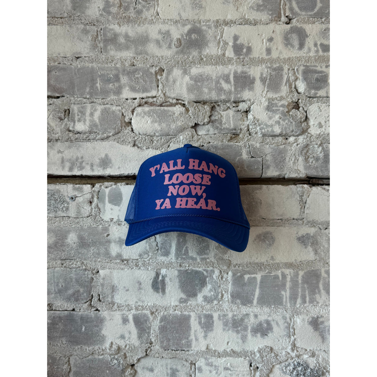 Y'all Hang Loose trucker hat by N.B. GOODS in royal blue and pink, featuring mesh back and adjustable snap closure.