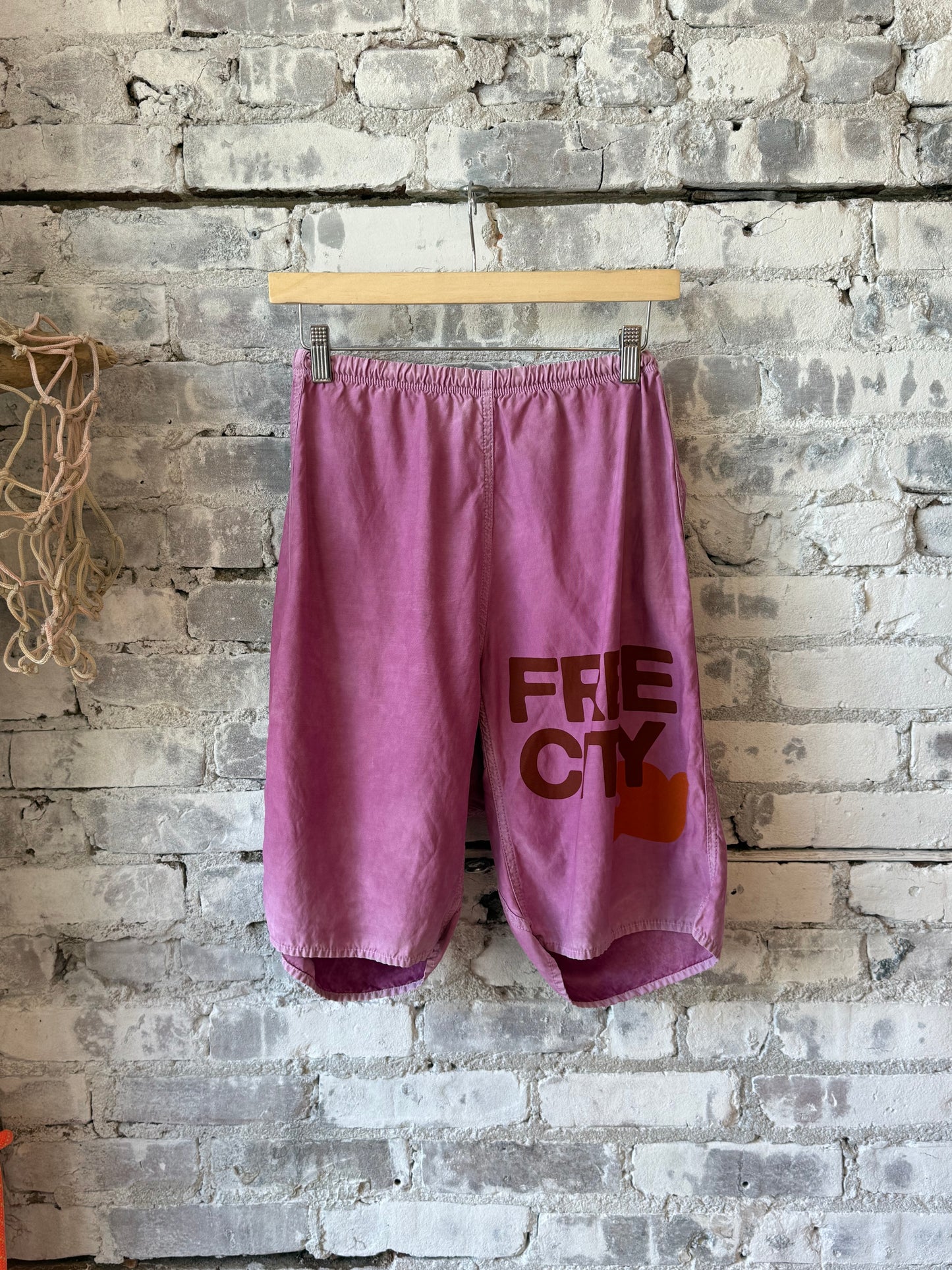 Women's Freecity matte satin back pocket shorts in Pinkshroom Powder, showing the stylish fabric and pocket details.