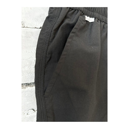 Men's black swim shorts with an elastic waistband and side pockets, designed for comfortable beach or poolside wear.
