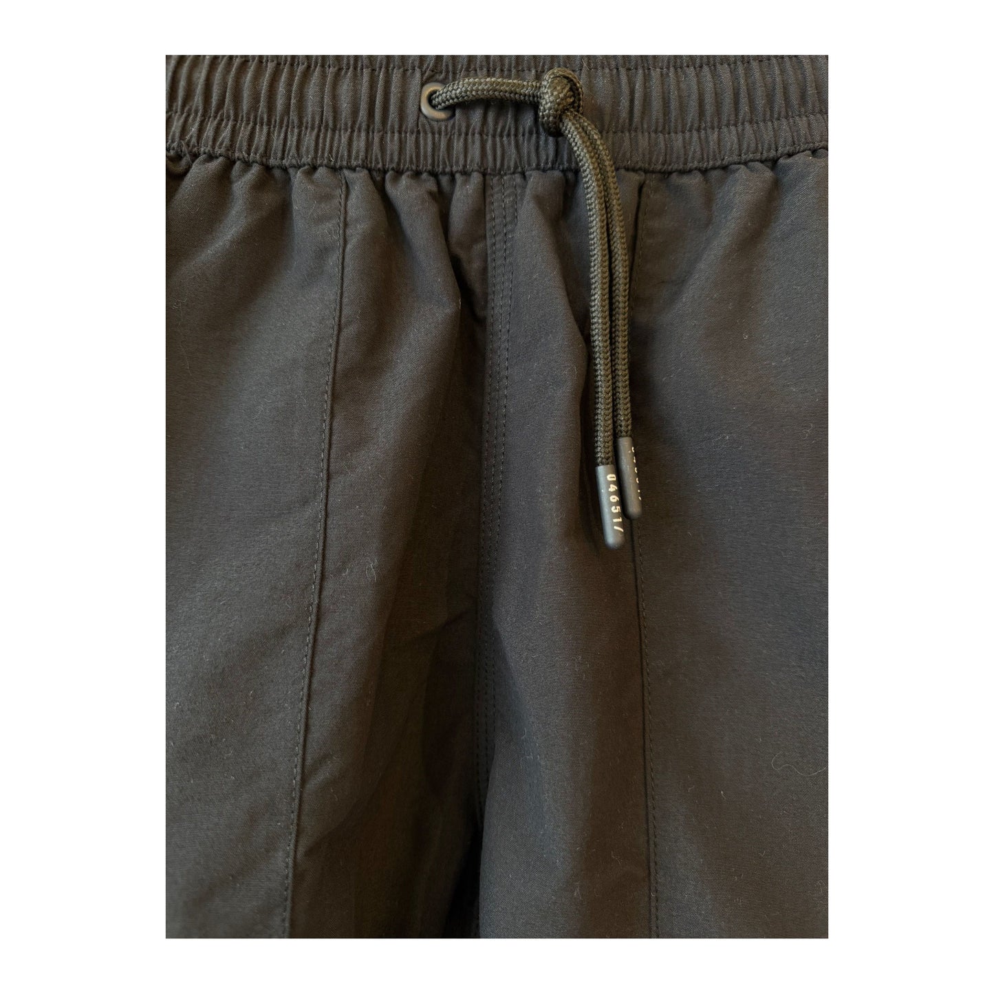 Men's black swim shorts with elastic waistband and side pockets, designed for comfortable beach or poolwear.