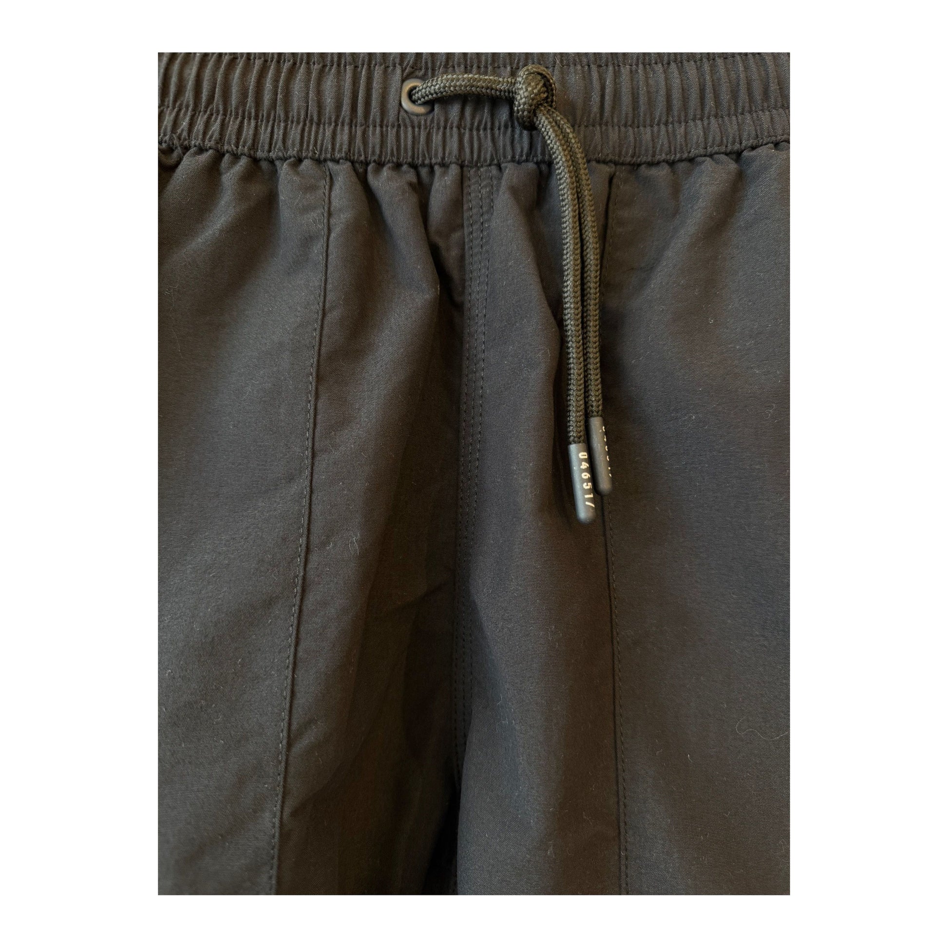 Men's black swim shorts with elastic waistband and side pockets, designed for comfortable beach or poolwear.