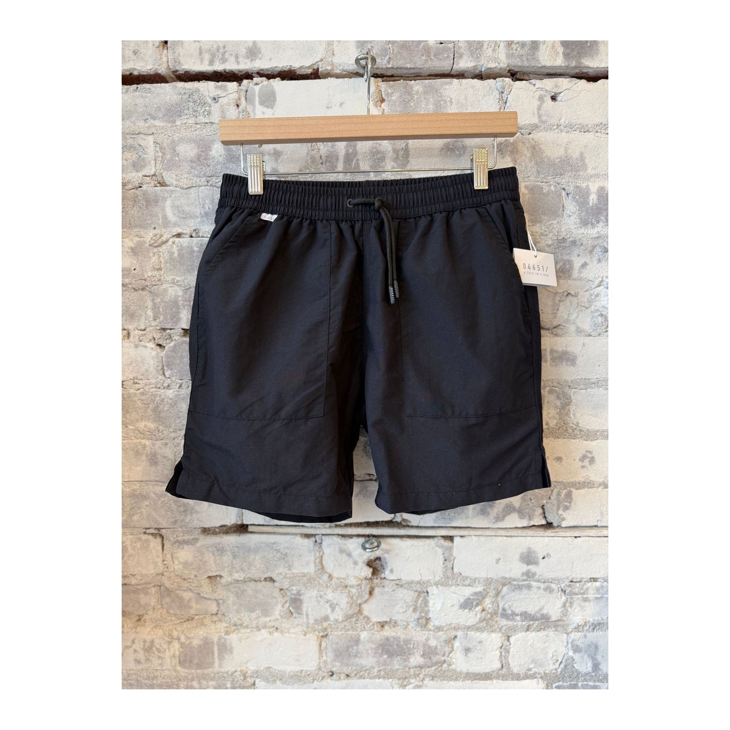 Men's black swim shorts with an elastic waistband and side pockets, perfect for beach or poolwear.