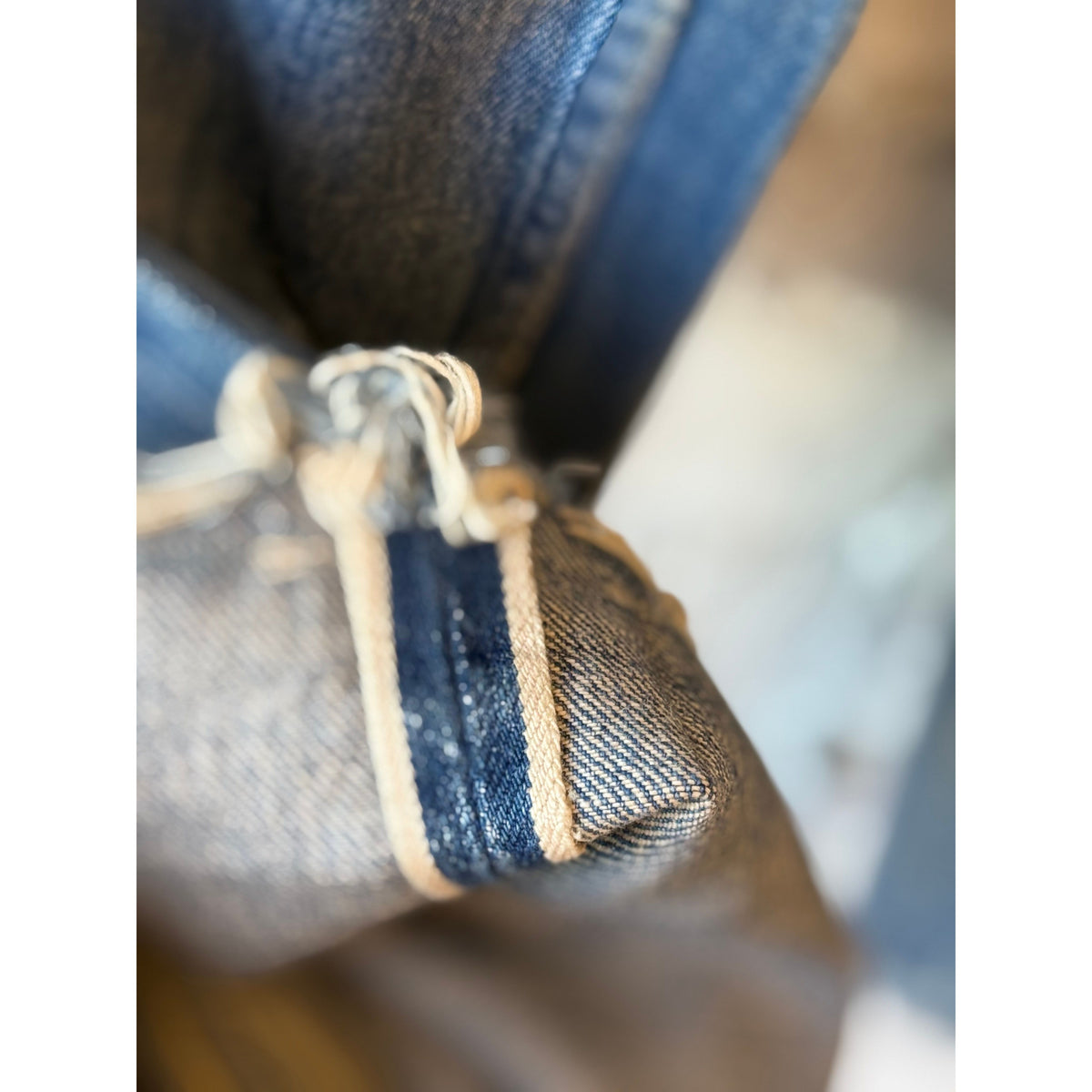 Women's dark distressed selvedge denim jeans with narrow straight cut by Chimala, showcasing detailed distressing and classic fit.