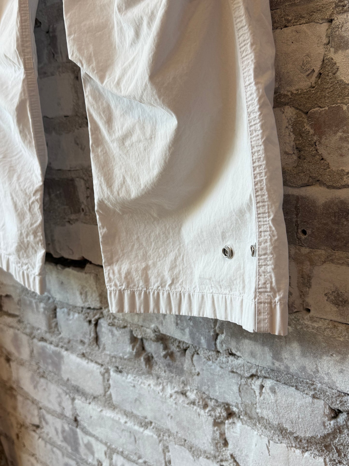 Women's white kite pant by Freecity with poplin fabric, air flap, and snap closure, featuring a relaxed fit and subtle design details.