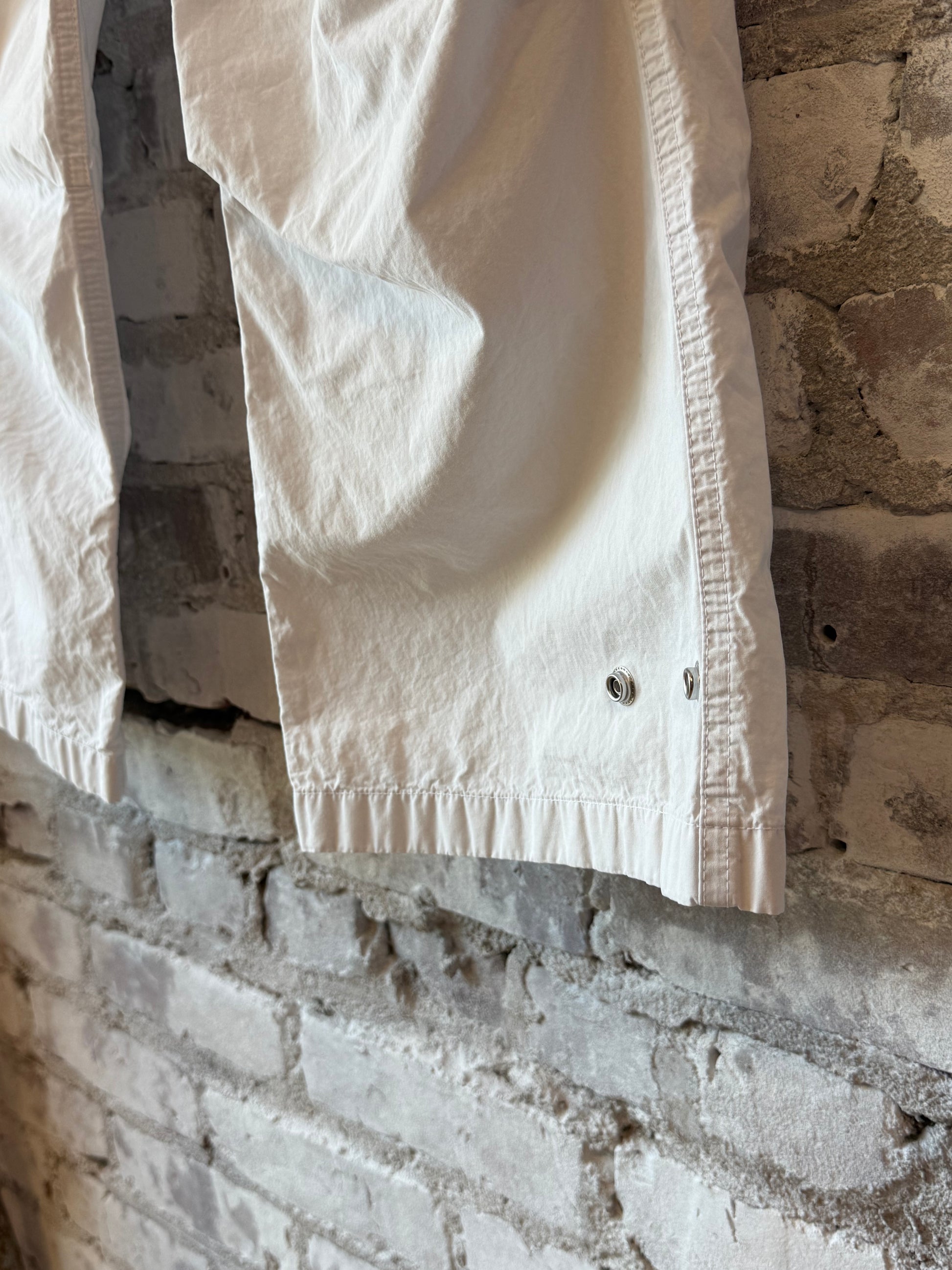Women's white kite pant by Freecity with poplin fabric, air flap, and snap closure, featuring a relaxed fit and subtle design details.