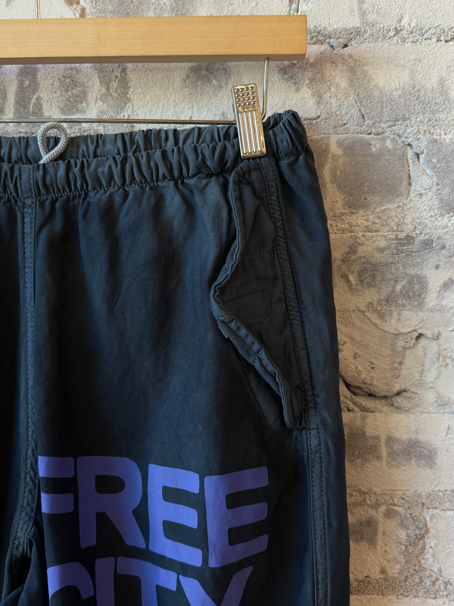 Women's Freecity Airjump pants in matte satin fabric with flap and snap details, featuring Moonshrooms design.