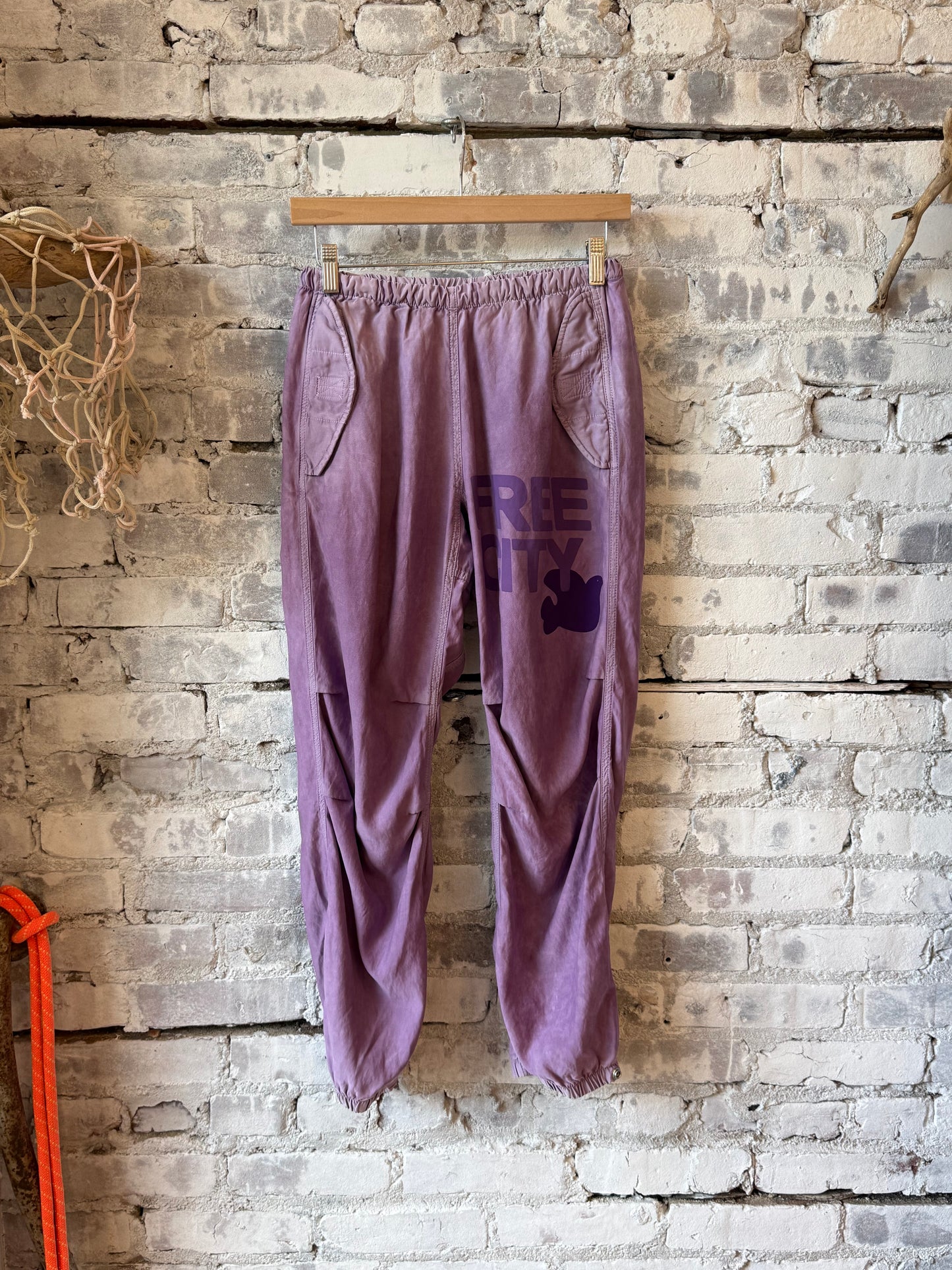 Women's Freecity AirJump Pant in matte satin, large flap and snap details, shown in Bloom color with a relaxed fit.