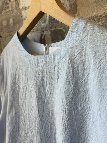 Women's violet top in blue from Secular, featuring a stylish design, displayed on a hanger against a neutral background.