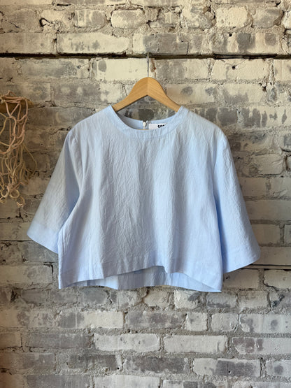 Women's violet top by Secular featuring a stylish blue design, showcased on a hanger with a simple background.