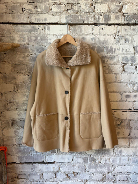 Women's Isabella reversible shearling jacket in sand by ARMA, showing the cozy shearling exterior and stylish reversible design.