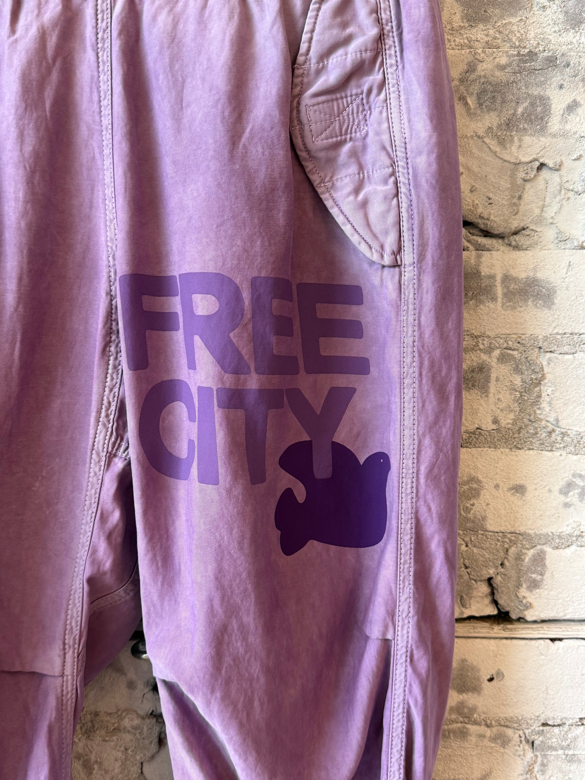Women's Freecity Airjump pants in matte satin Bloom color, featuring a flap and snap-free design with a loose fit and stylish look.
