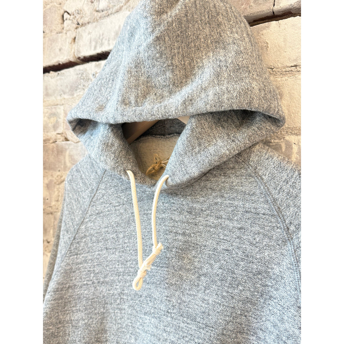 Men's Kepani Manchester 2 gray pullover hoodie, soft fabric, front pocket, casual style, displayed on a hanger.