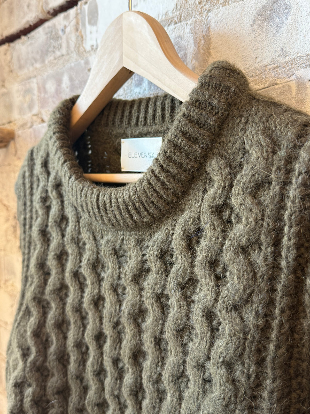 Women's Amara Sweater in dark olive by ELEVEN SIX, featuring a cozy knit design and ribbed cuffs.
