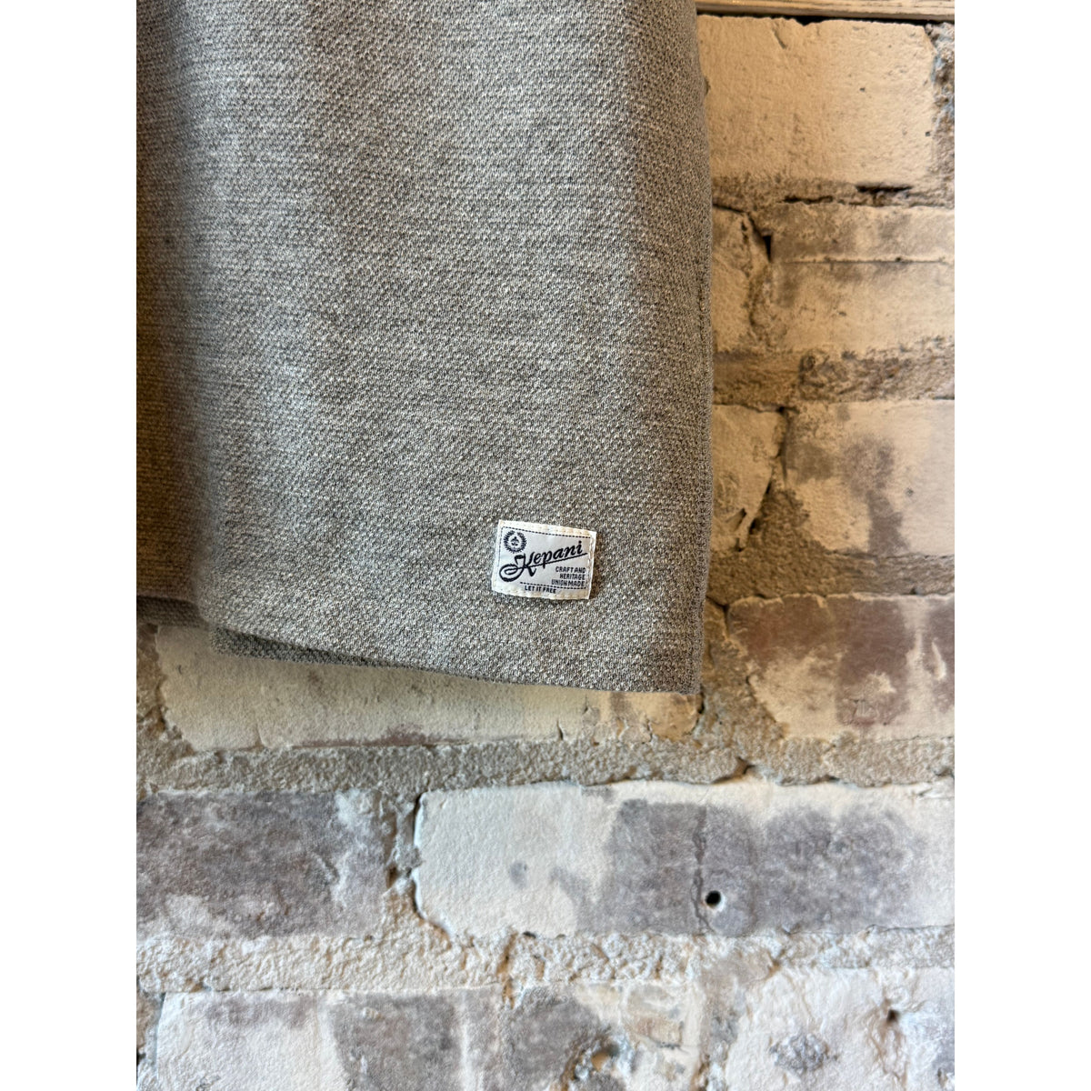 Men's Kepani Raffy Pique Knit Polo Shirt in light gray, featuring a classic collar and short sleeves, laid flat on a neutral background.