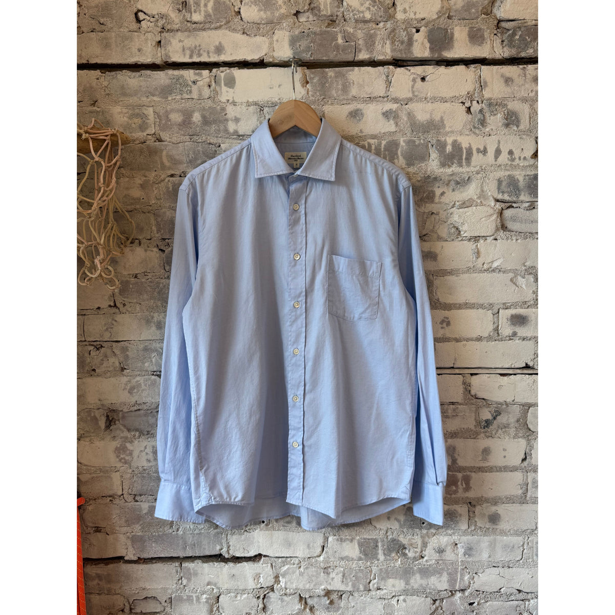 Men's Paul Woven Shirt in Sky Blue by Hartford Men's, shown on a hanger with a close-up of the woven fabric and collar details.