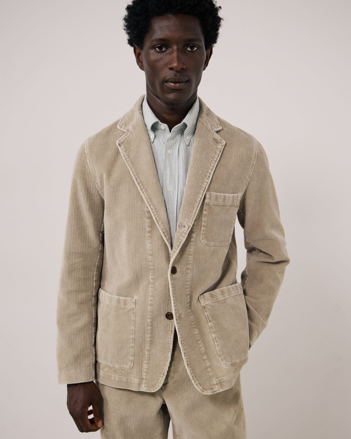 Hartford Men's Julian Woven Jacket in sand color, featuring a textured woven fabric and classic design, displayed on a hanger.