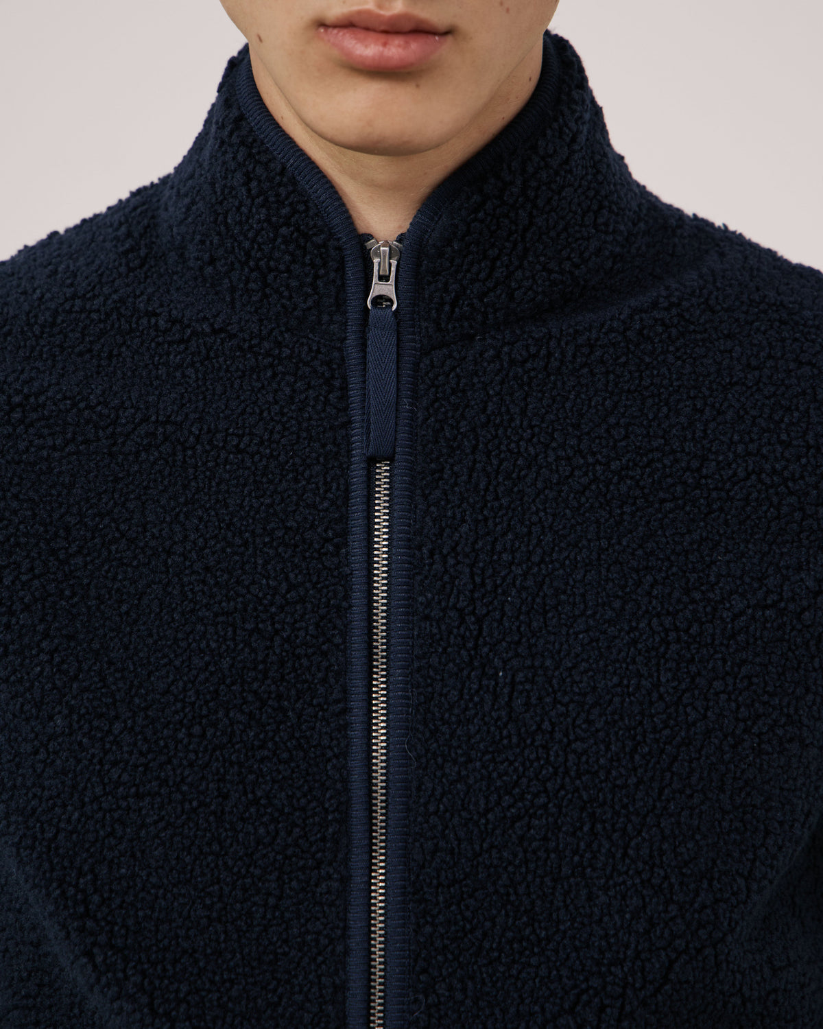 Navy knitted vest for men by Hartford Men's, featuring a classic V-neck design and ribbed hem, styled on a mannequin.