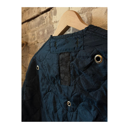 Women's military liner grommets in navy by Sloppy Seconds, close-up of durable metal grommets on navy fabric.