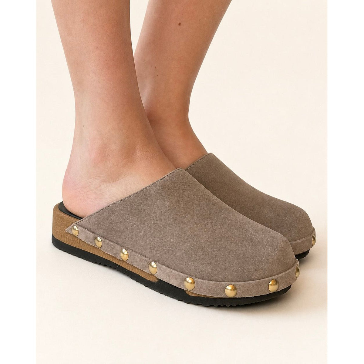Brown clog shoe with gold studs on a white background