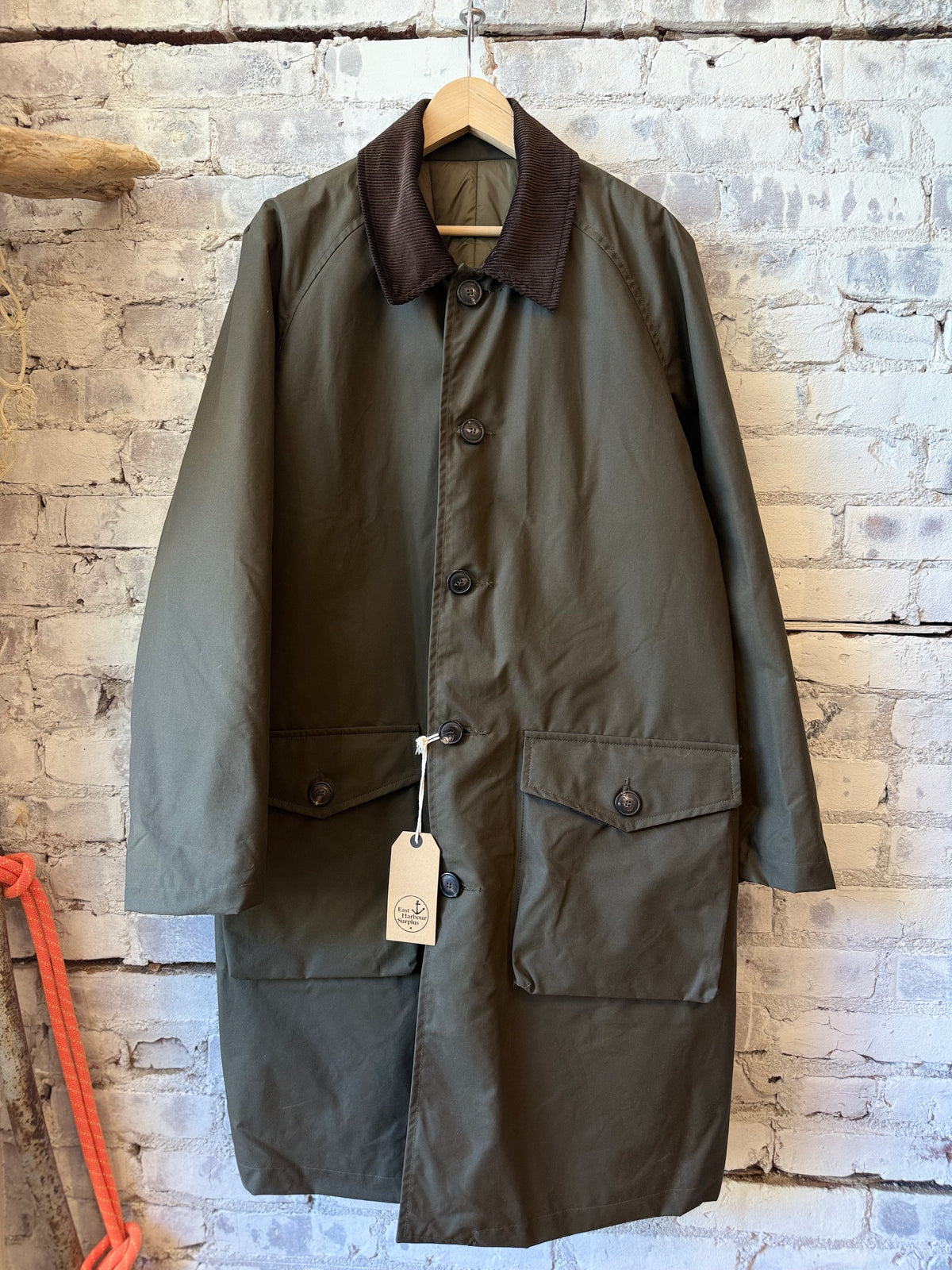 Men's green waxed cotton trench coat by East Harbour Surplus, stylish men's outerwear with a classic design and durable fabric.