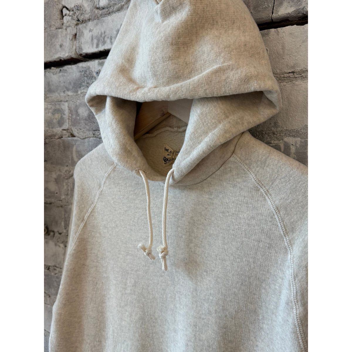 Men's Kepani Manchester 2 Pullover Hoodie in oatmeal, showing the soft fabric, hood, and front pocket design.