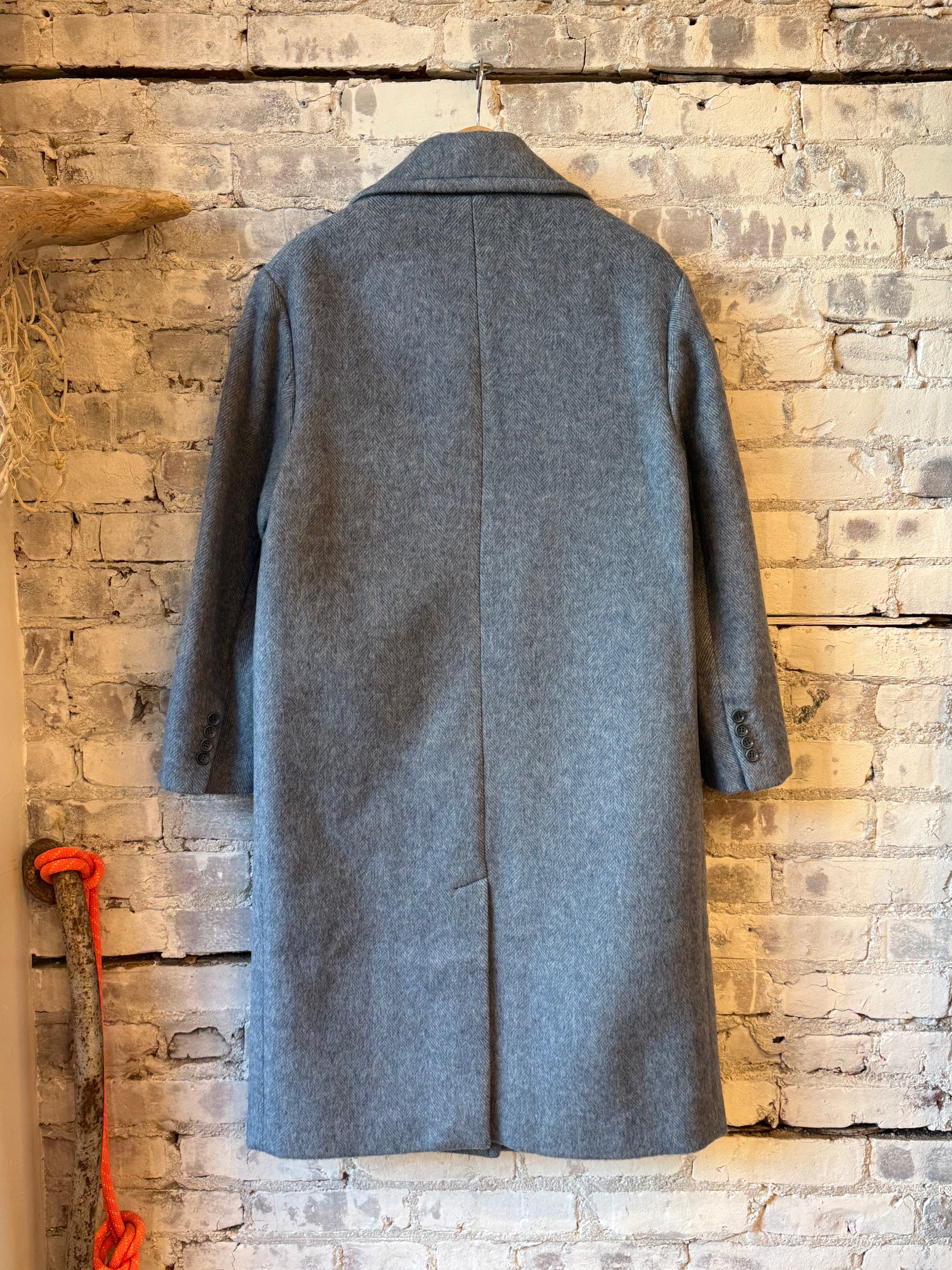 Women's sky blue wool coat by Aspesi, shown hanging on a wooden hanger against a neutral background.