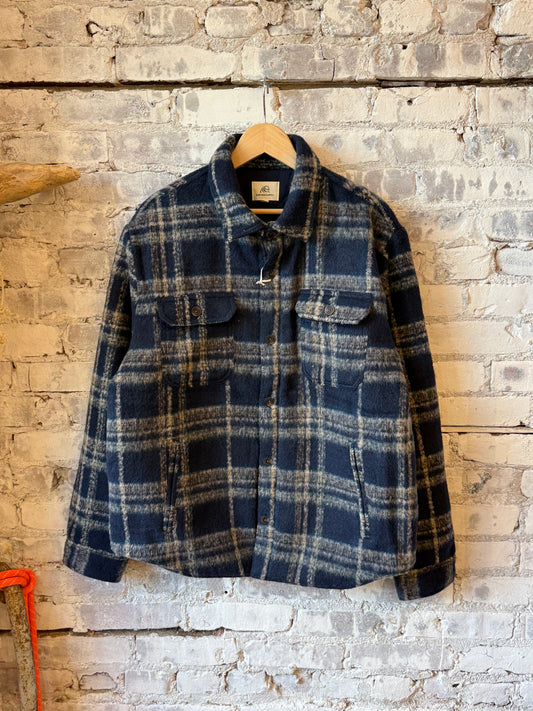 Men's navy quilted plaid shirt jacket by Surfside Supply, featuring warm, soft quilted fabric and classic plaid pattern.