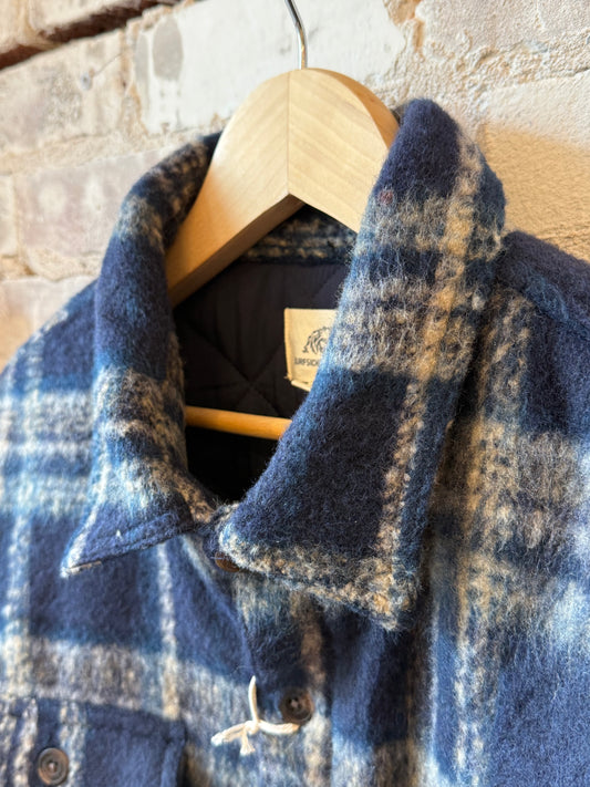 Men's navy quilted plaid shirt jacket by Surfside Supply featuring a cozy, quilted plush fabric and classic plaid design.