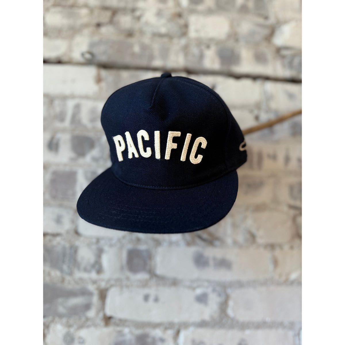 Pacific IV Snapback hat in navy and white by The Ampal Creative, featuring a structured crown and adjustable snapback closure.